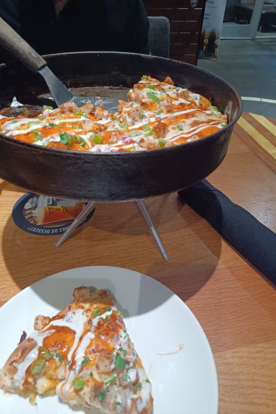 buffalo chicken style pizza with a slice placed on a plate