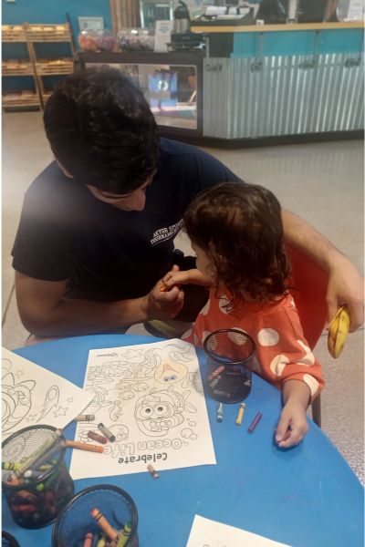 my daughter coloring with her dad in a public playspace