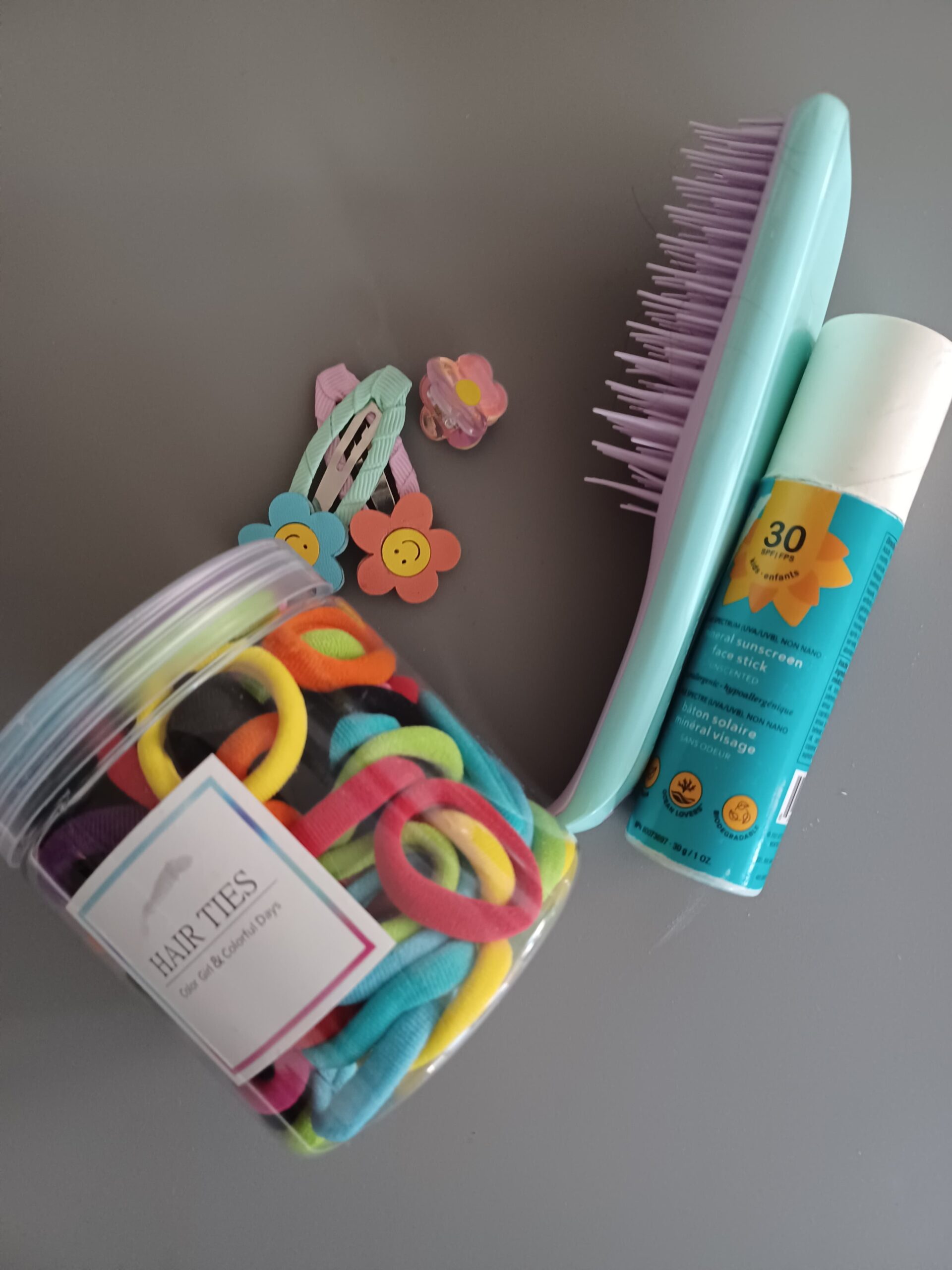 hairbrush, scrunchies, hair clips and sunscreen we use for my little as a part of her toddler morning routine