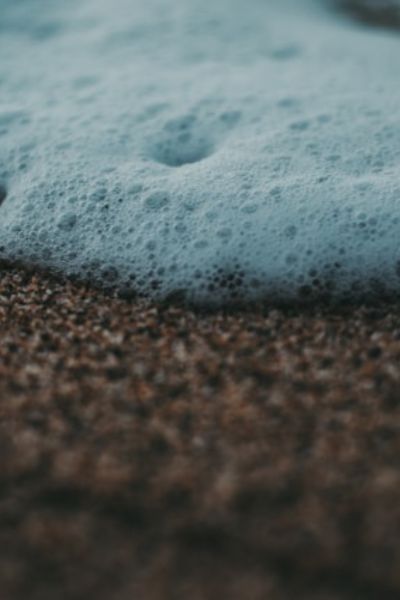 seaside foam on a rocky formation indicating harsher abrasives that are sometimes found in toothpastes