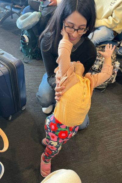 my toddler and I in the airport. she's leaning back on me while we await to board the plane