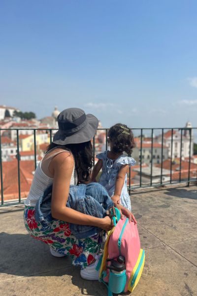 my toddler and I looking out at the city of LIsbon. I'm crouching down next to her