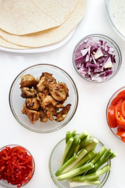 ingredients needed for toddler meal prep burrito bowls displayed in small glass bowls on a white counter