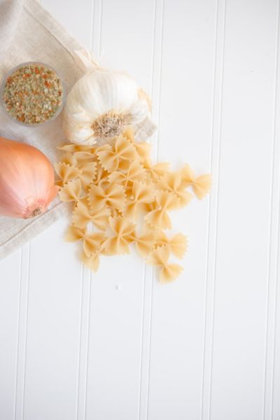 uncooked bowtie pasta by garlic